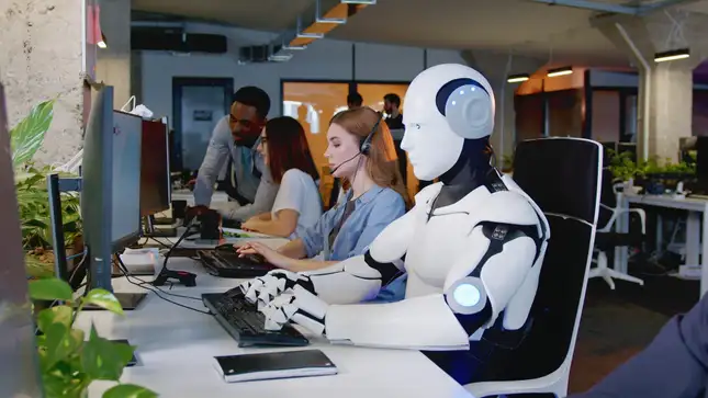 Robot working customer support sitting at computer