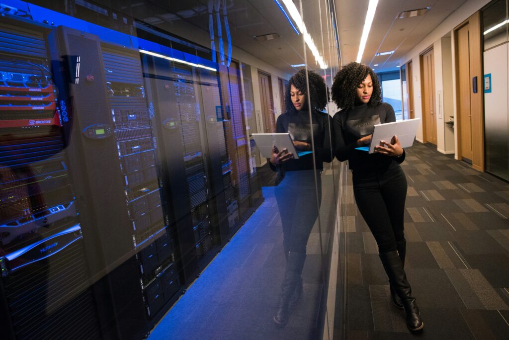 women leaning against server room glass